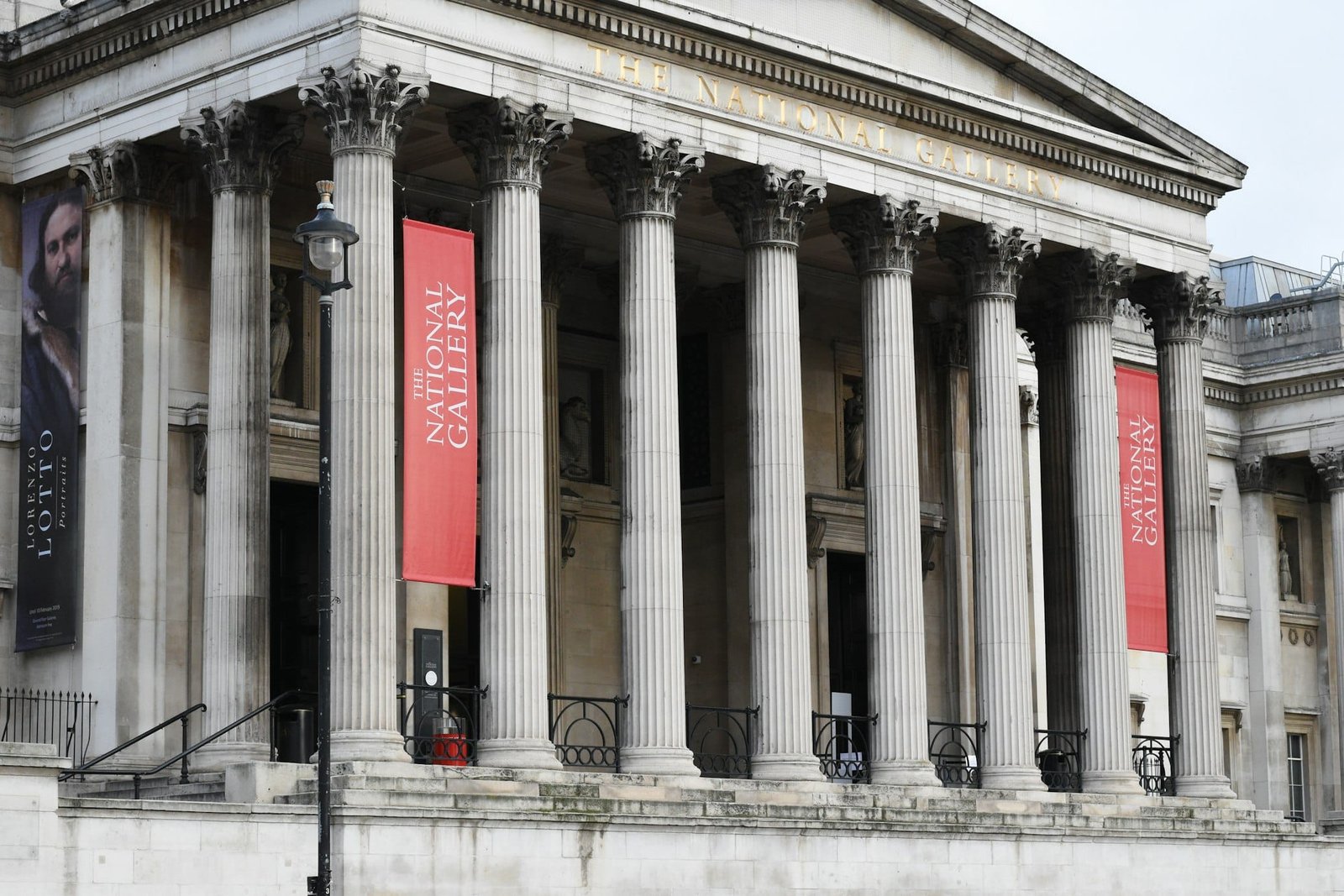 A fachada frontal da National Gallery, um dos pontos turísticos de Londres, com colunas altas, faixas e uma escadaria que leva à entrada.