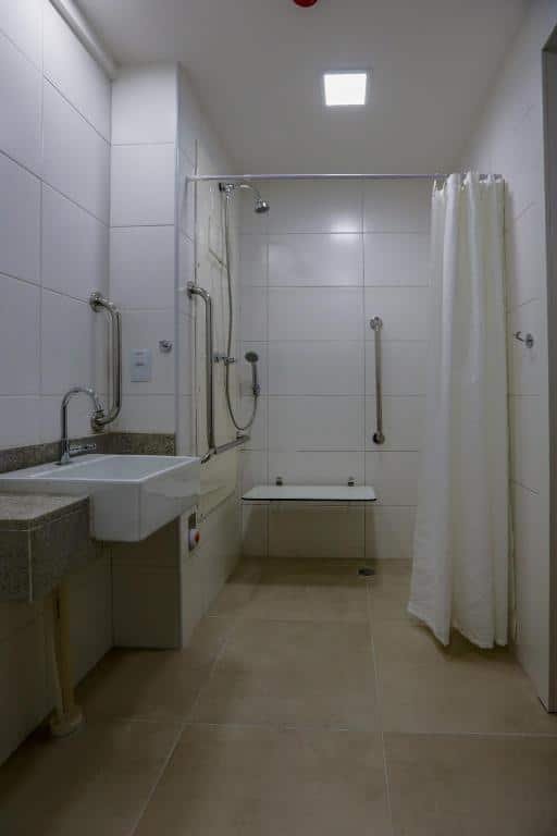 Um banheiro com barras no box e na pia.