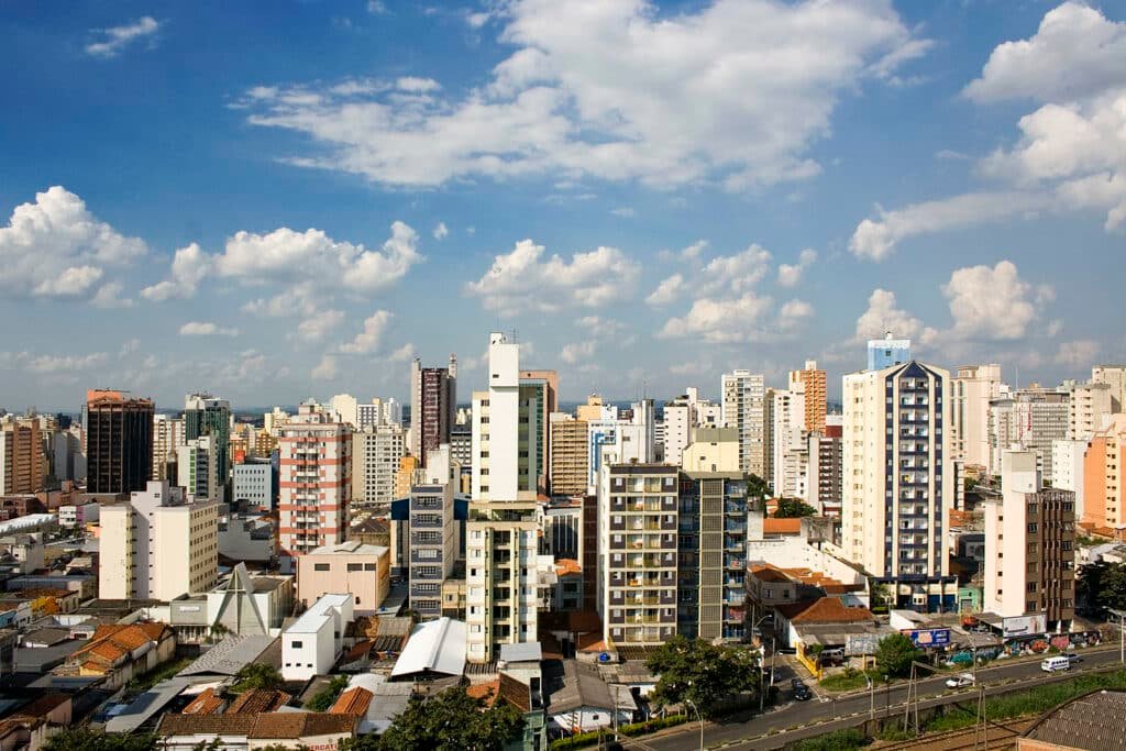 Foto de uma avenida em Campinas com muitos prédios e o céu cheio de nuvens