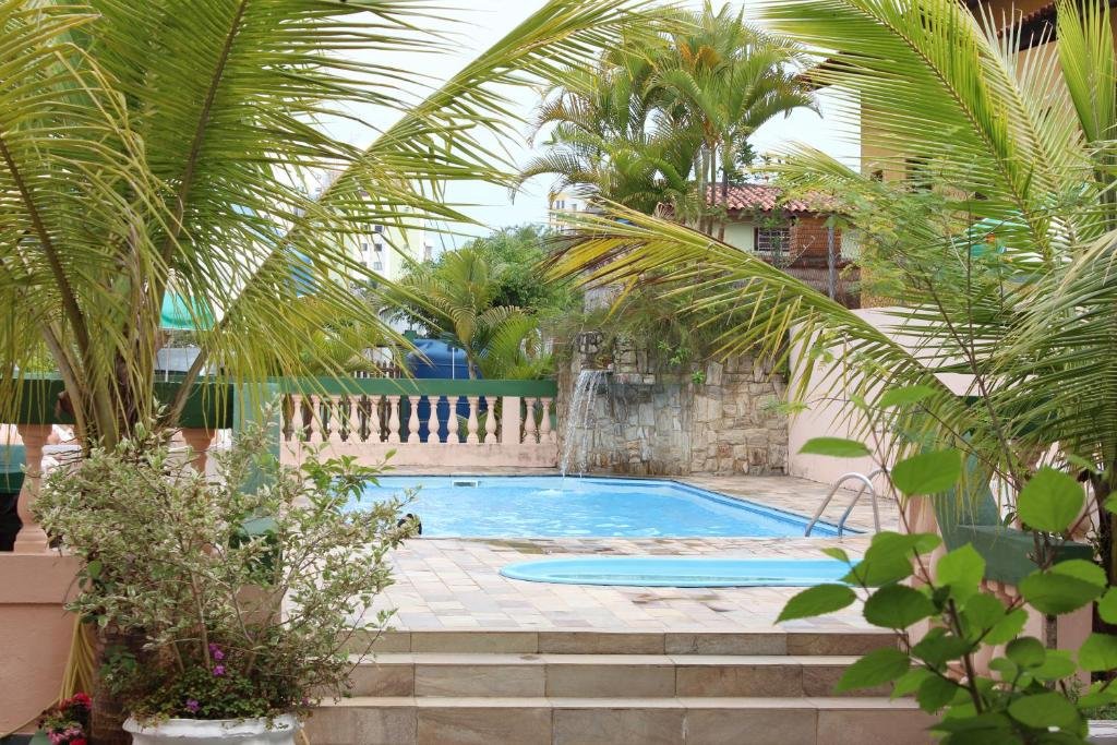 Parte da pousada Farol das Gaivotas Pousada e Residence que mostra uma piscina ao ar livre com algu,as plantas verdes em volta. imagem ilustrando post Pousadas pet friendly  no Litoral Norte de São Paulo.
