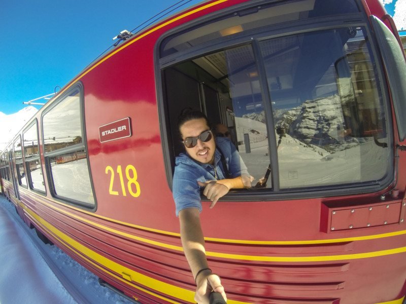 Homem tirando uma selfie na janela de um trem que vai para Jungfrau.
