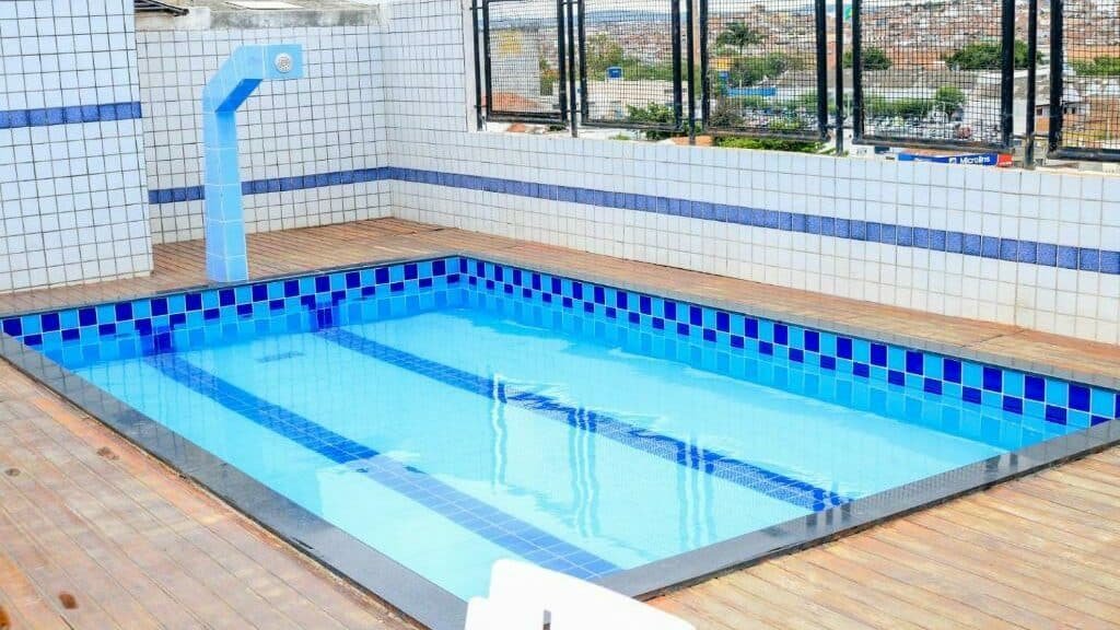 Terraço do Center Plaza Hotel com uma piscina e grades ao lado que dão vista para a cidade. 