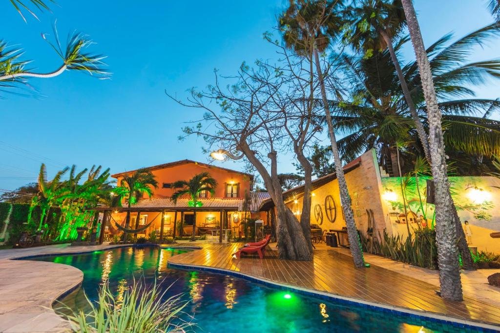 área da piscina da vila parnaíba com deque de madeira e coqueiros ao redor