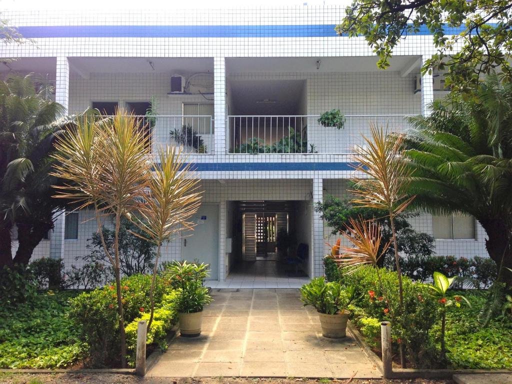 Entrada da pousada, um segundo andar, com um caminho na frente e um jardim ao redor. Foto para ilustrar post sobre hotéis perto do Consulado Americano em Recife.