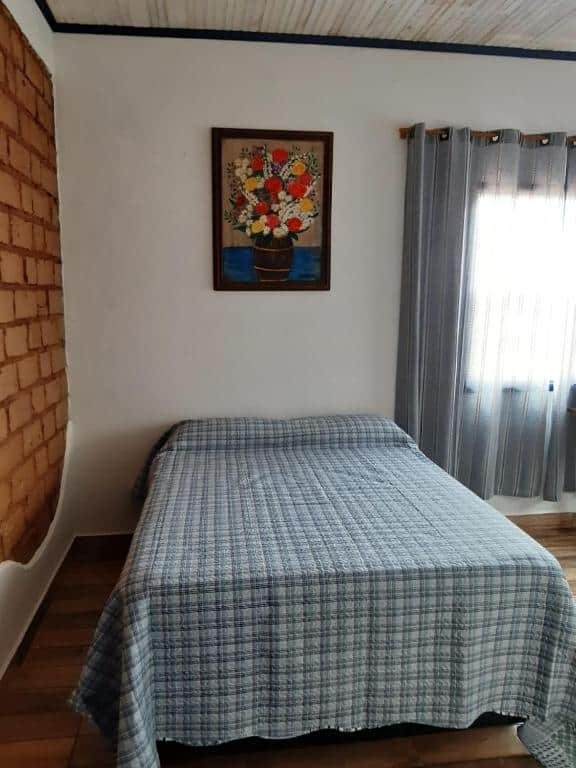 quarto com cama de casal da Casa Rústica em Tiradentes