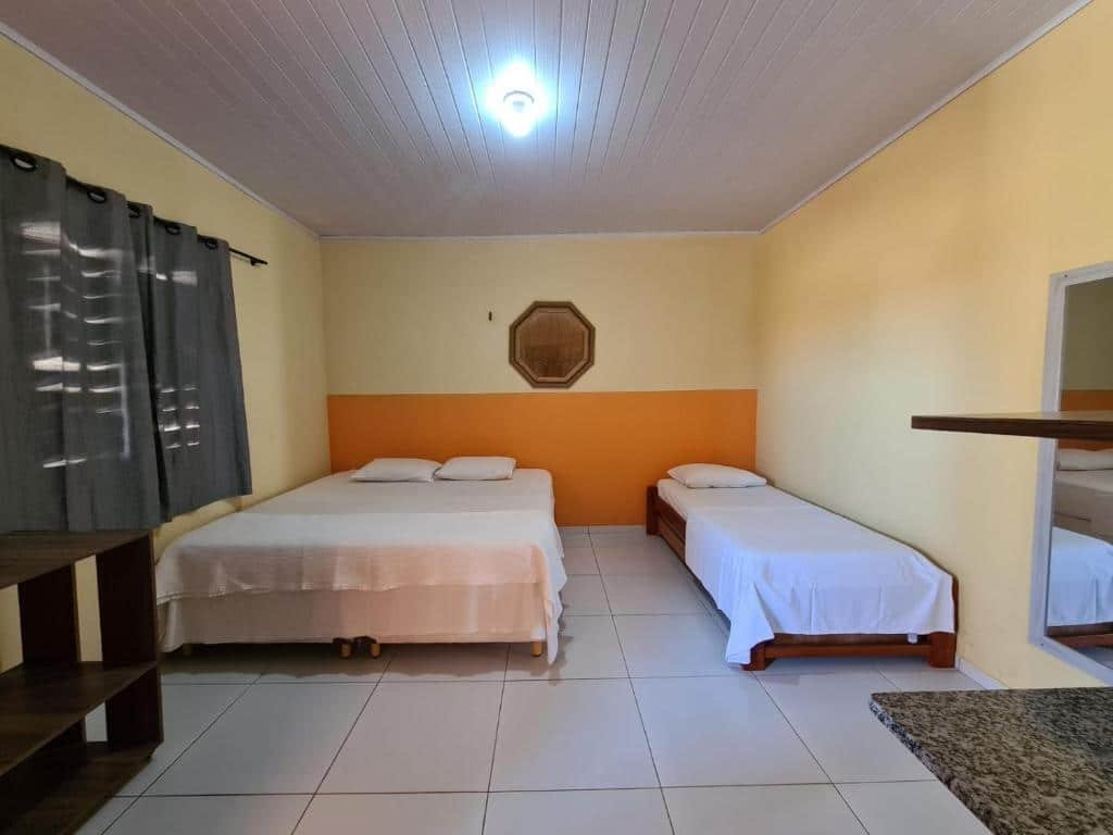 Quarto com cama de casal e de solteiro na Pousada Sonho de Mar.
