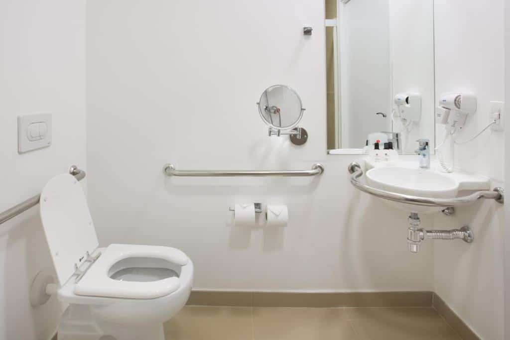 Banheiro do Ramada by Wyndham Campinas Viracopos com barras de apoio perto da privada e da pia adaptada