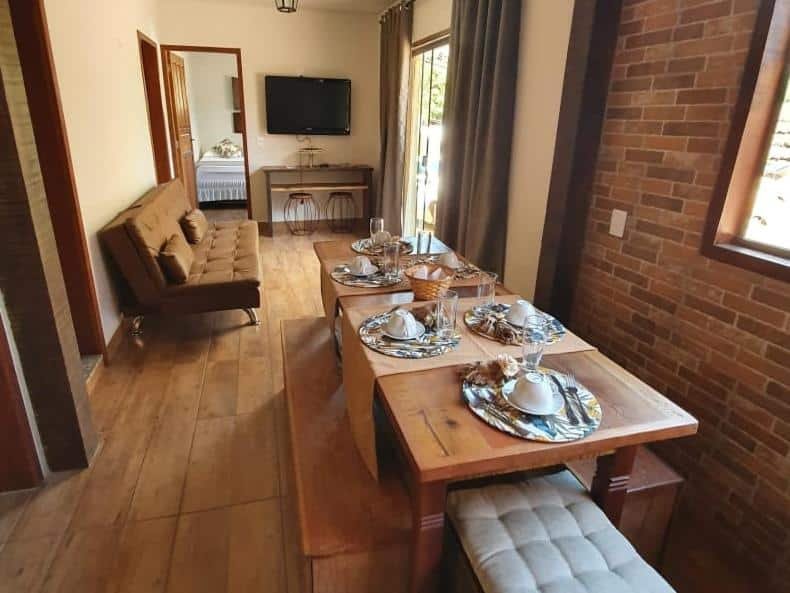 sala com mesa no Recanto da Vó Bia uma opção de airbnb em Tiradentes