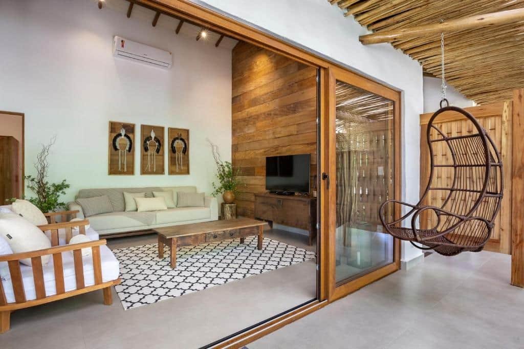 Sala de estar da Flamboyant Residence Quadrado com sofá do lado esquerdo da imagem com uma mesa de centro e em frente uma cômoda com TV.