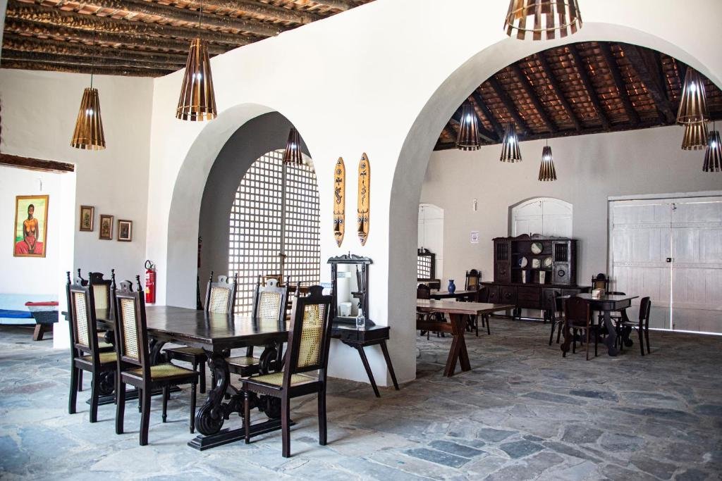 Sala com mesas e cadeiras na Pousada Porto das Barcas em Parnaíba.
