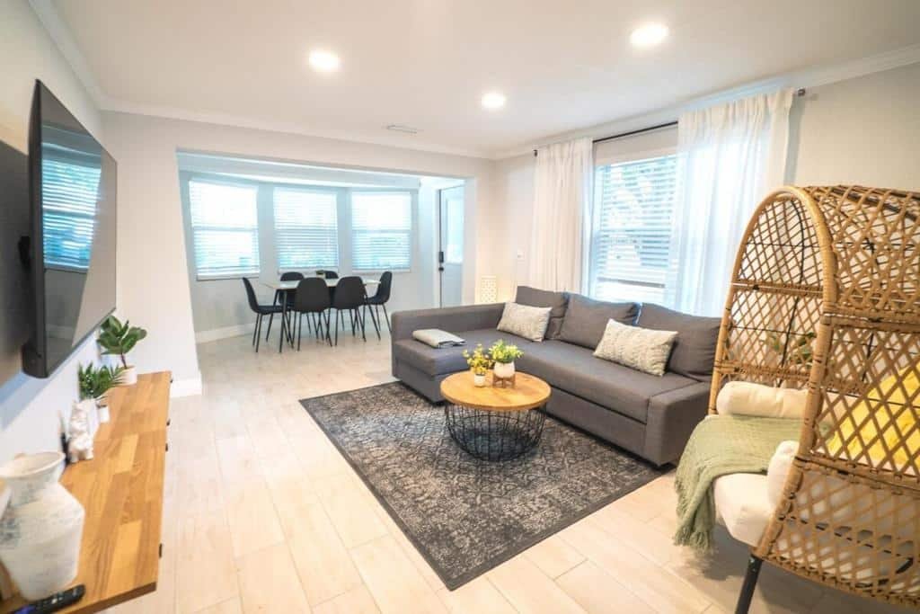 Sala de estar da Tranquil & Fully Renoveted Home Near Busch Gardens com um sofá de três lugares, um poltrona em estilo rústico, uma televisão e uma mesa com seis lugares perto da janela